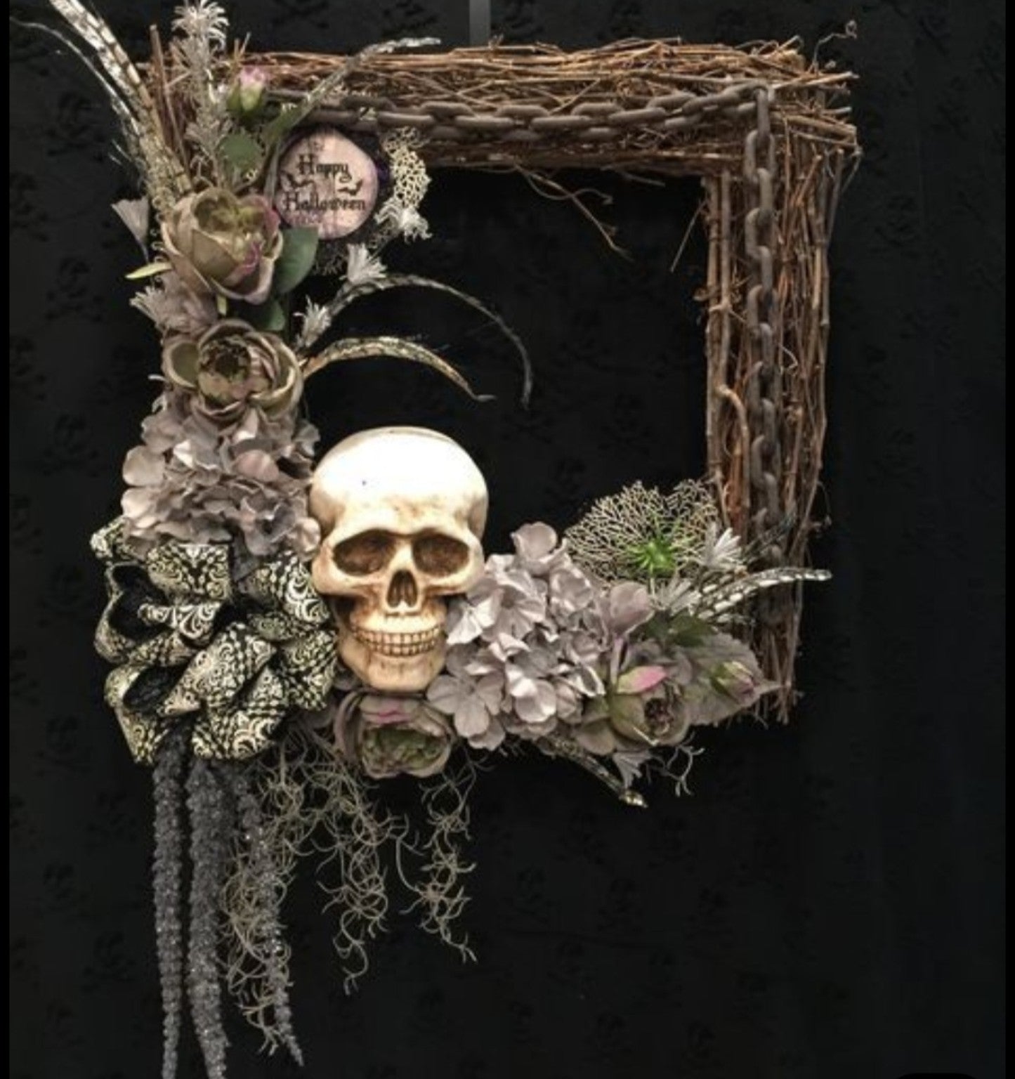 Spooky Wreath Workshop example with skull, flowers, ribbon, and grapevine frame